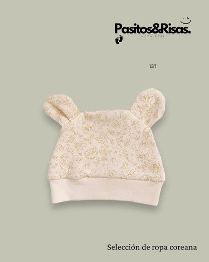 Gorro con orejas que añade un toque adorable al conjunto mientras protege la cabeza del bebé.